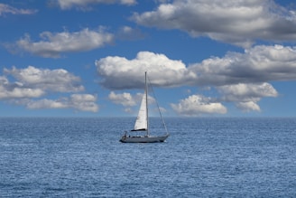 A sailboat floating in the middle of the ocean