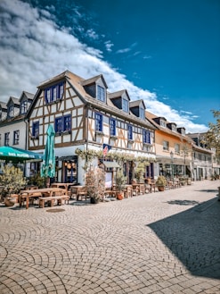 A large building with lots of tables and chairs in front of it