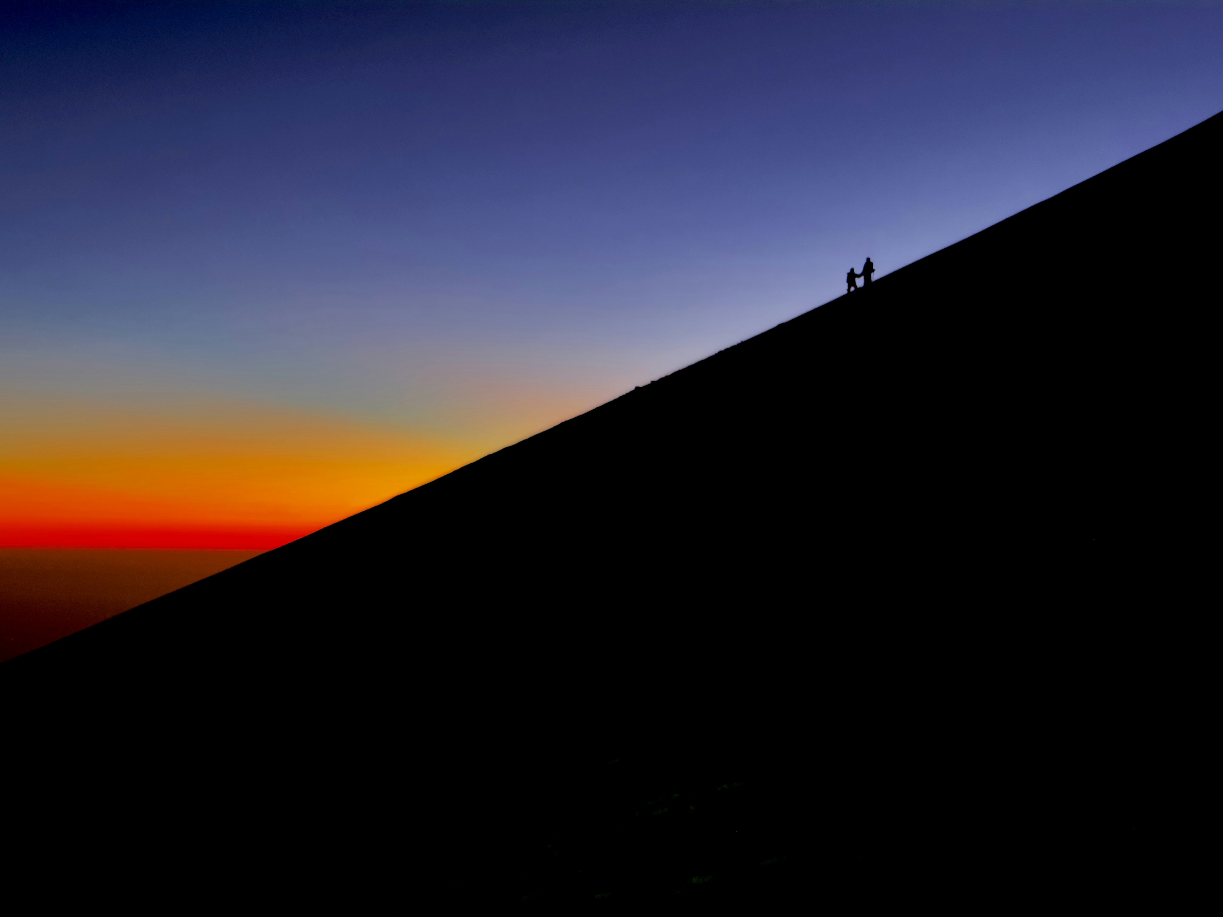 A couple of people standing on top of a hill