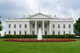 A large white building with a fountain in front of it