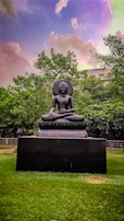A buddha statue sitting in the middle of a field