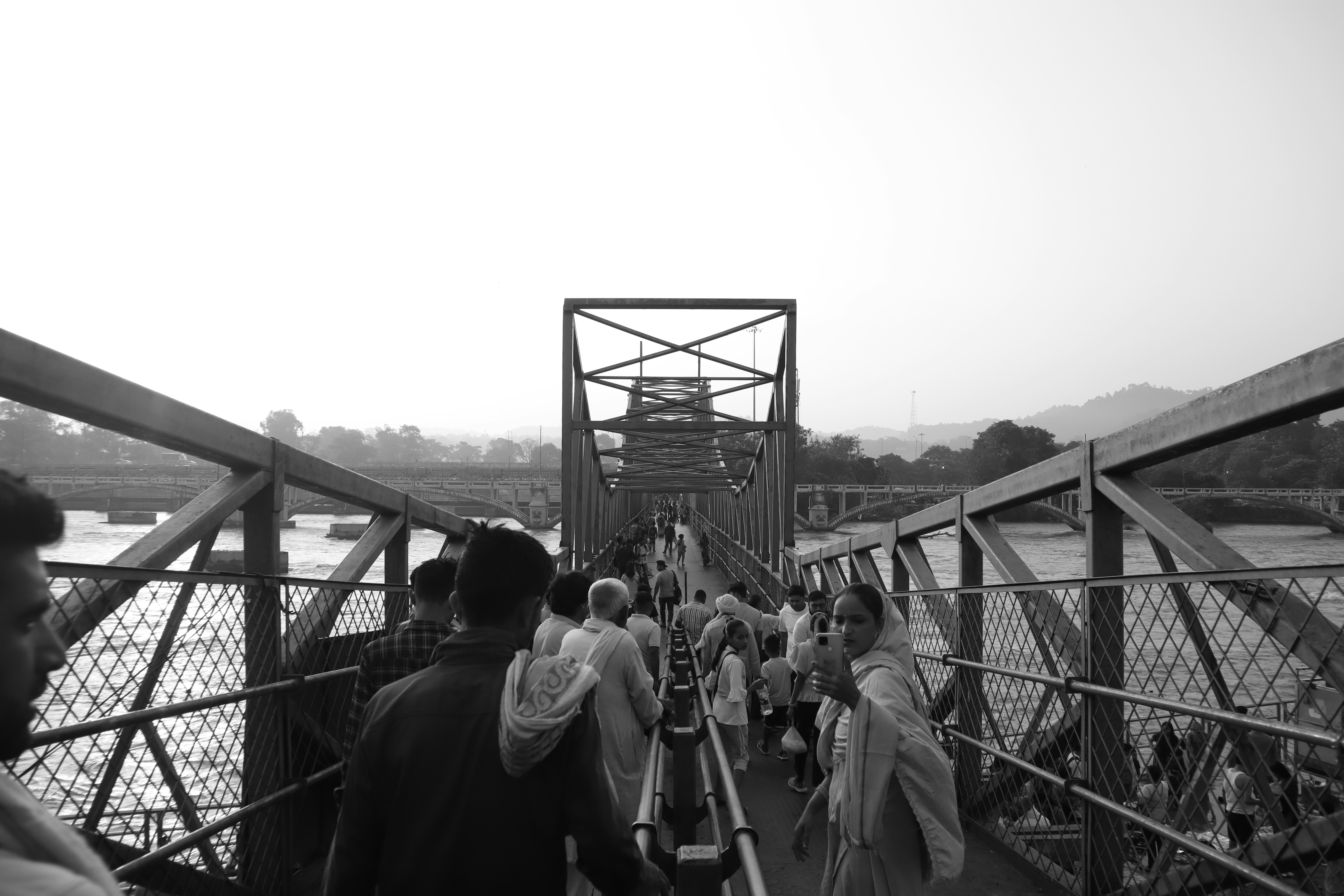 A group of people walking across a bridge
