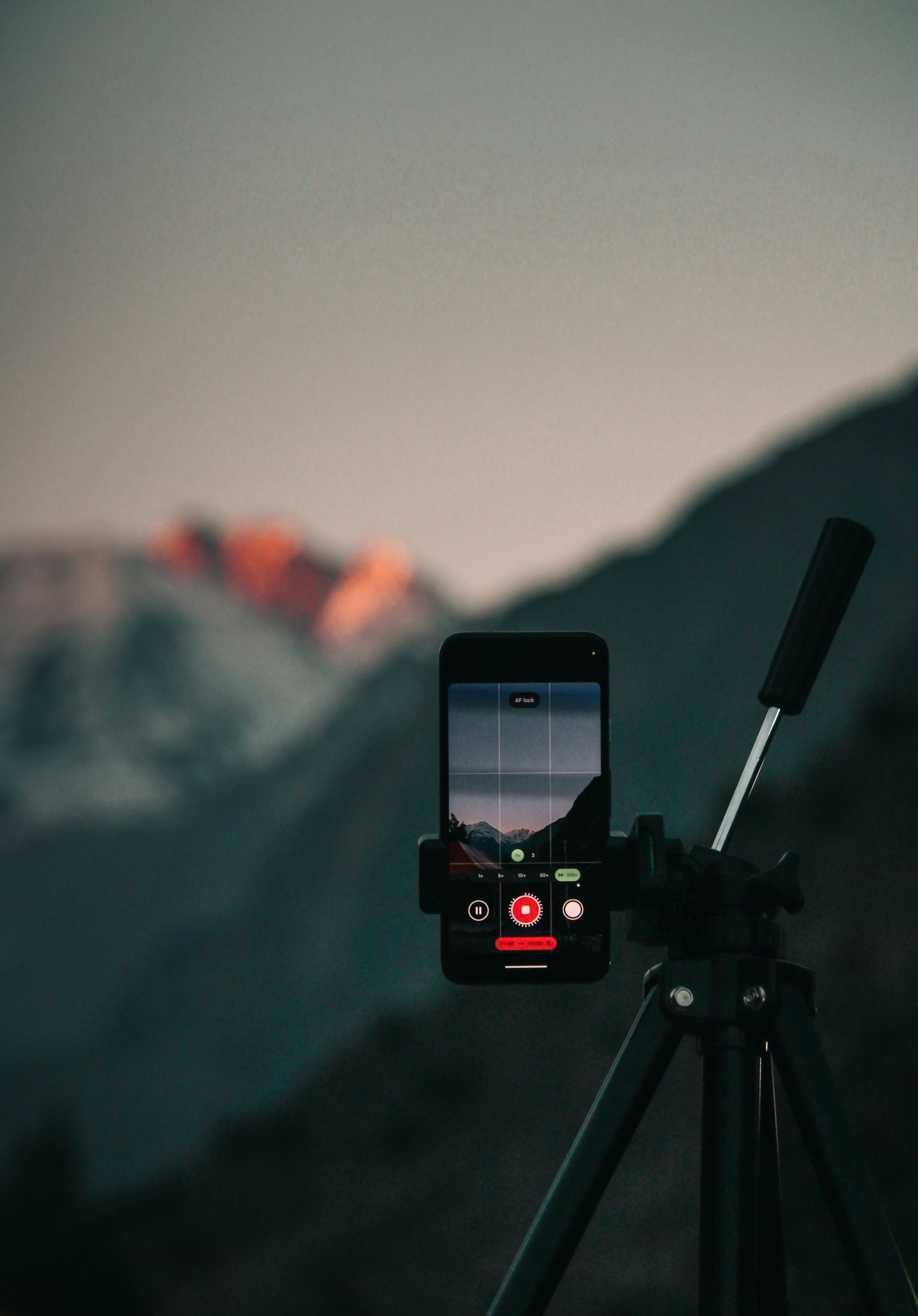 A tripod with a cell phone on top of it