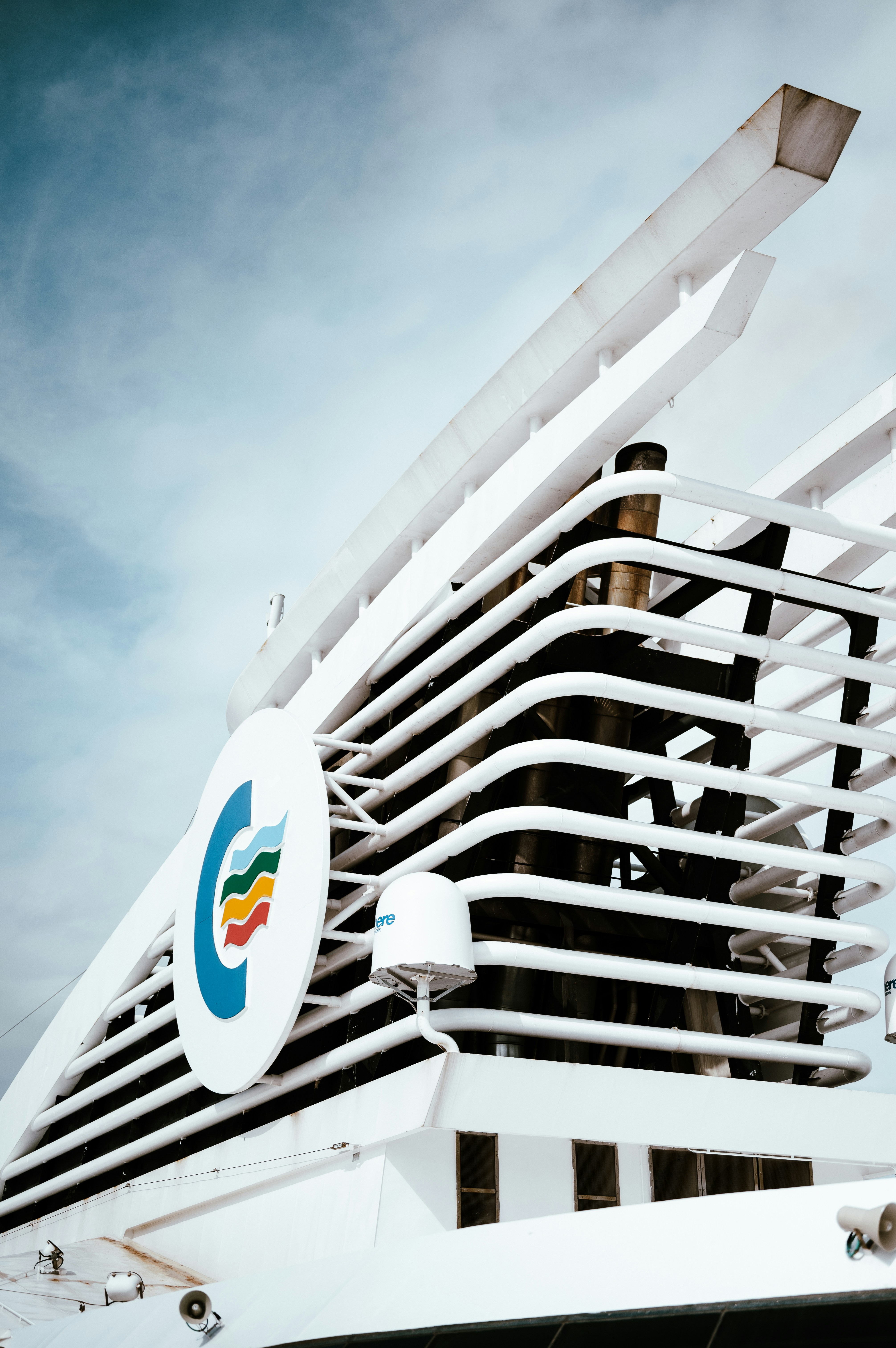 A large cruise ship with a rainbow logo on it's side