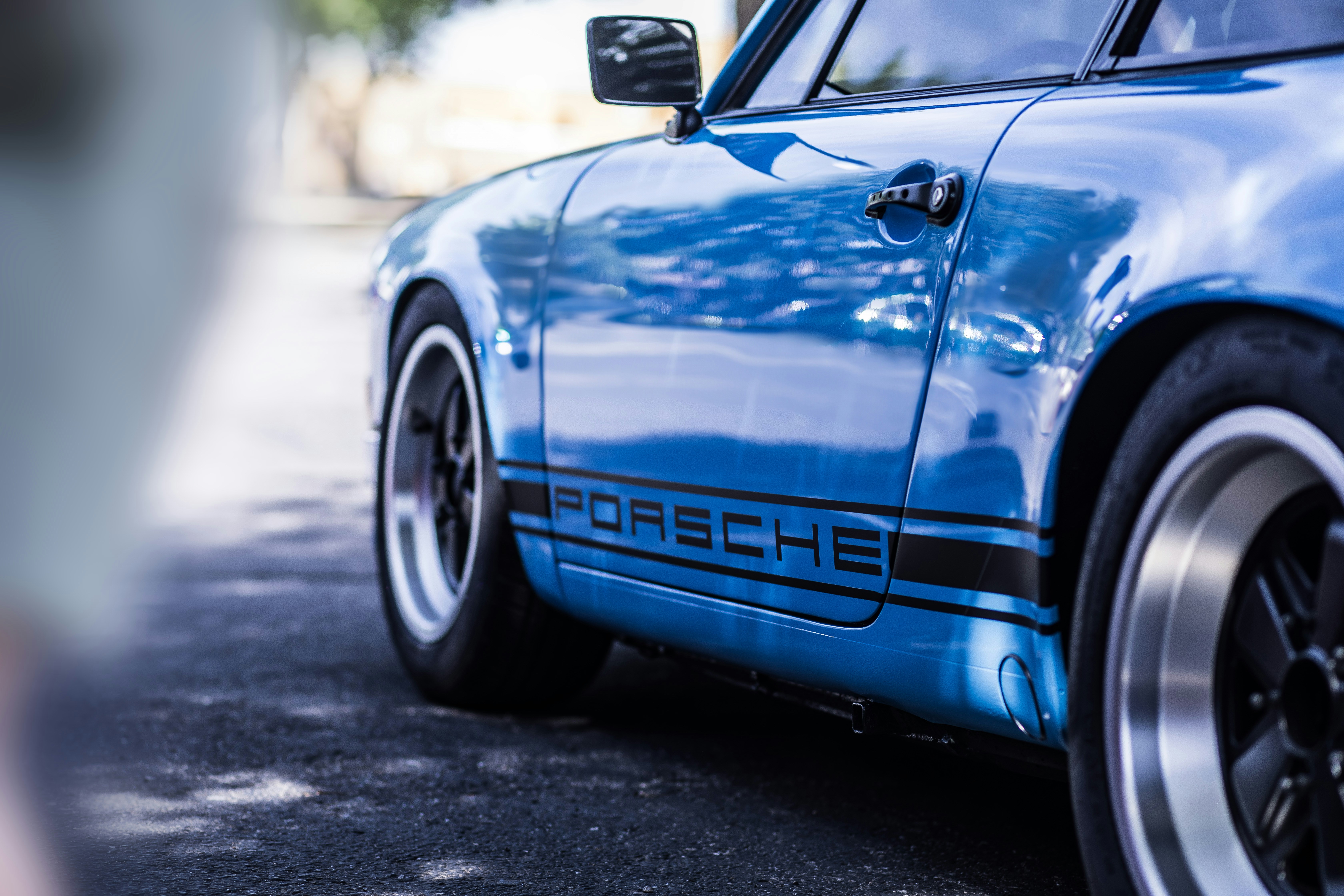 A blue porsche parked on the side of the road