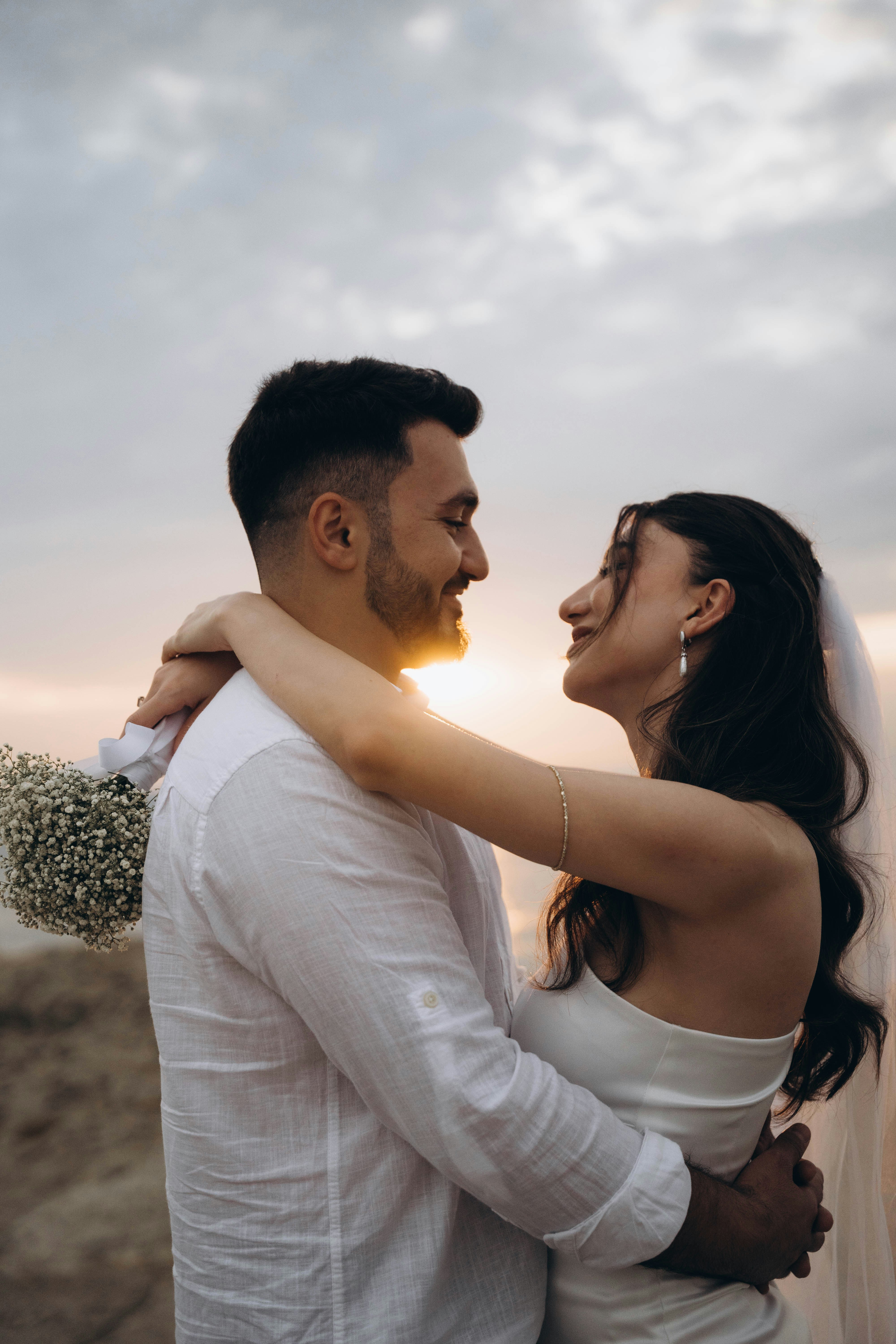 A bride and groom embracing each other on the beach