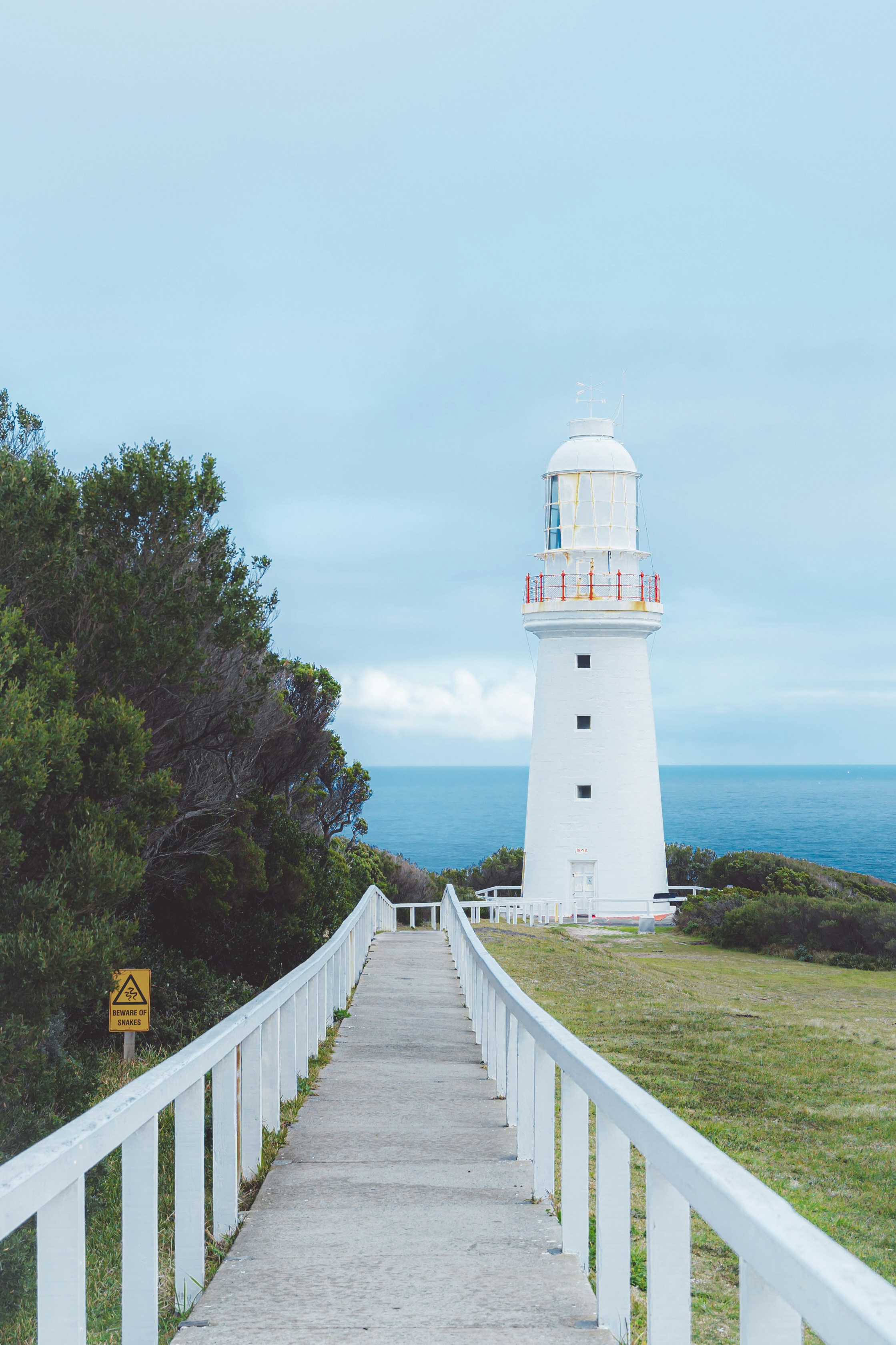 A walkway leading to a light house on a hill