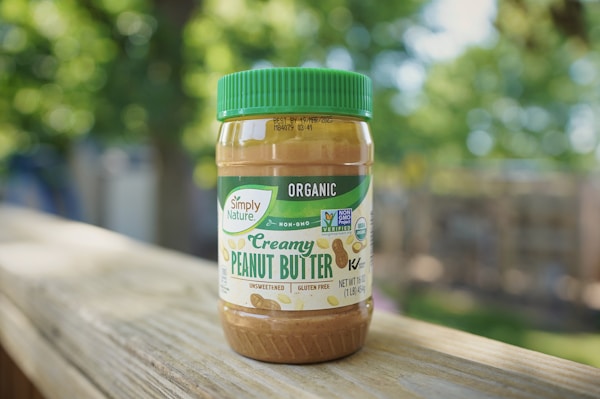 A jar of peanut butter sitting on top of a wooden table