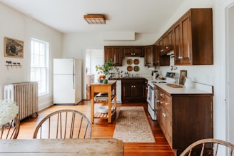 A kitchen with wooden floors and a table and chairs