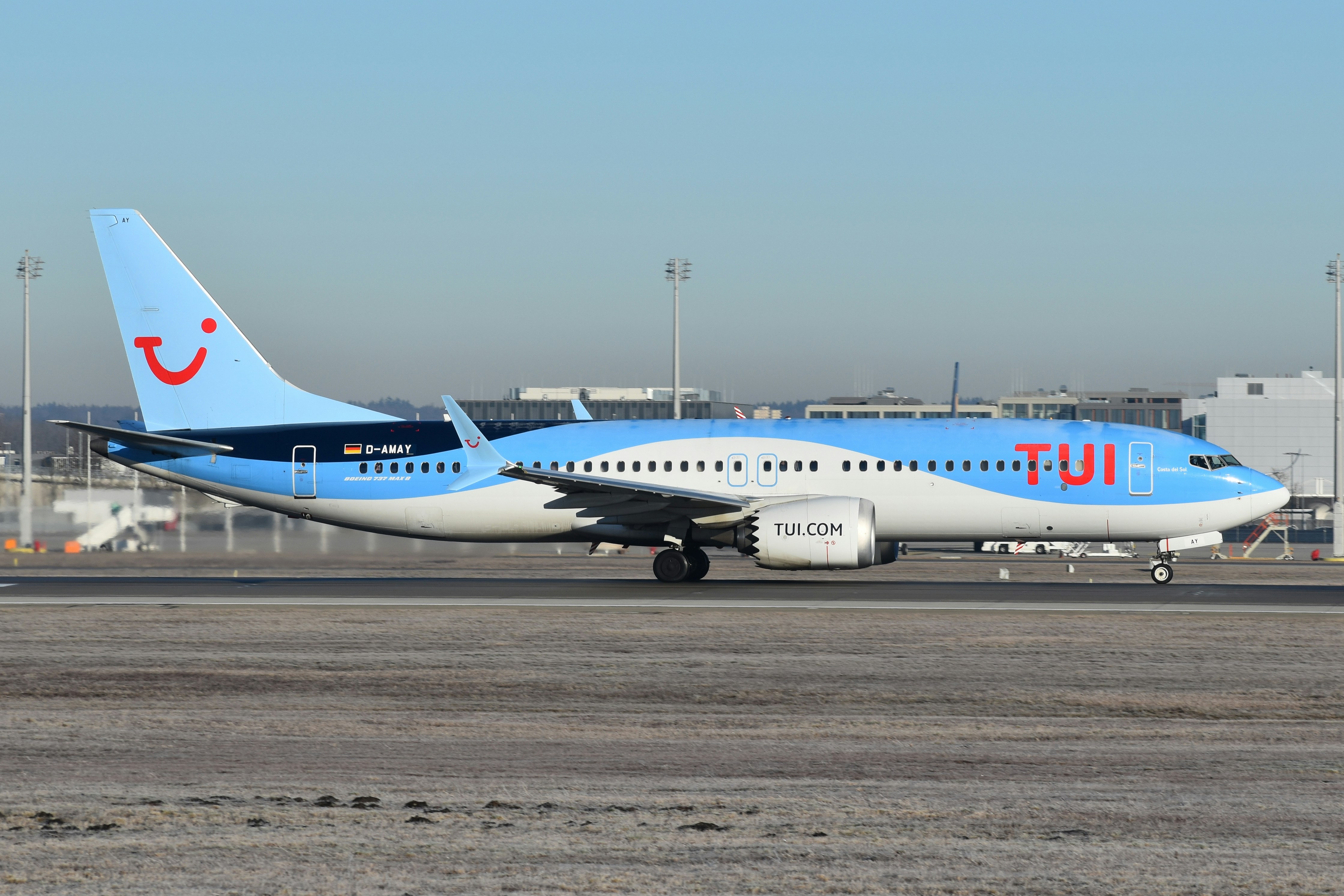 A blue and white airplane is on the runway, TUI Airways 737 MAX 8 at Munich Airport