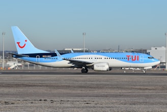 A blue and white airplane is on the runway