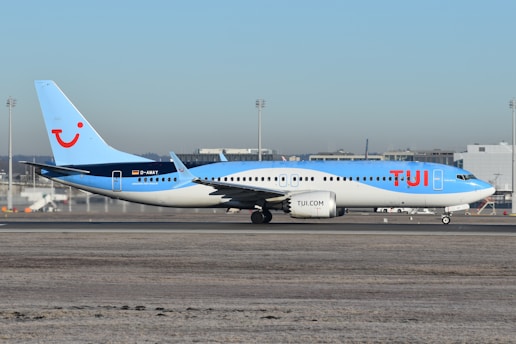 A blue and white airplane is on the runway