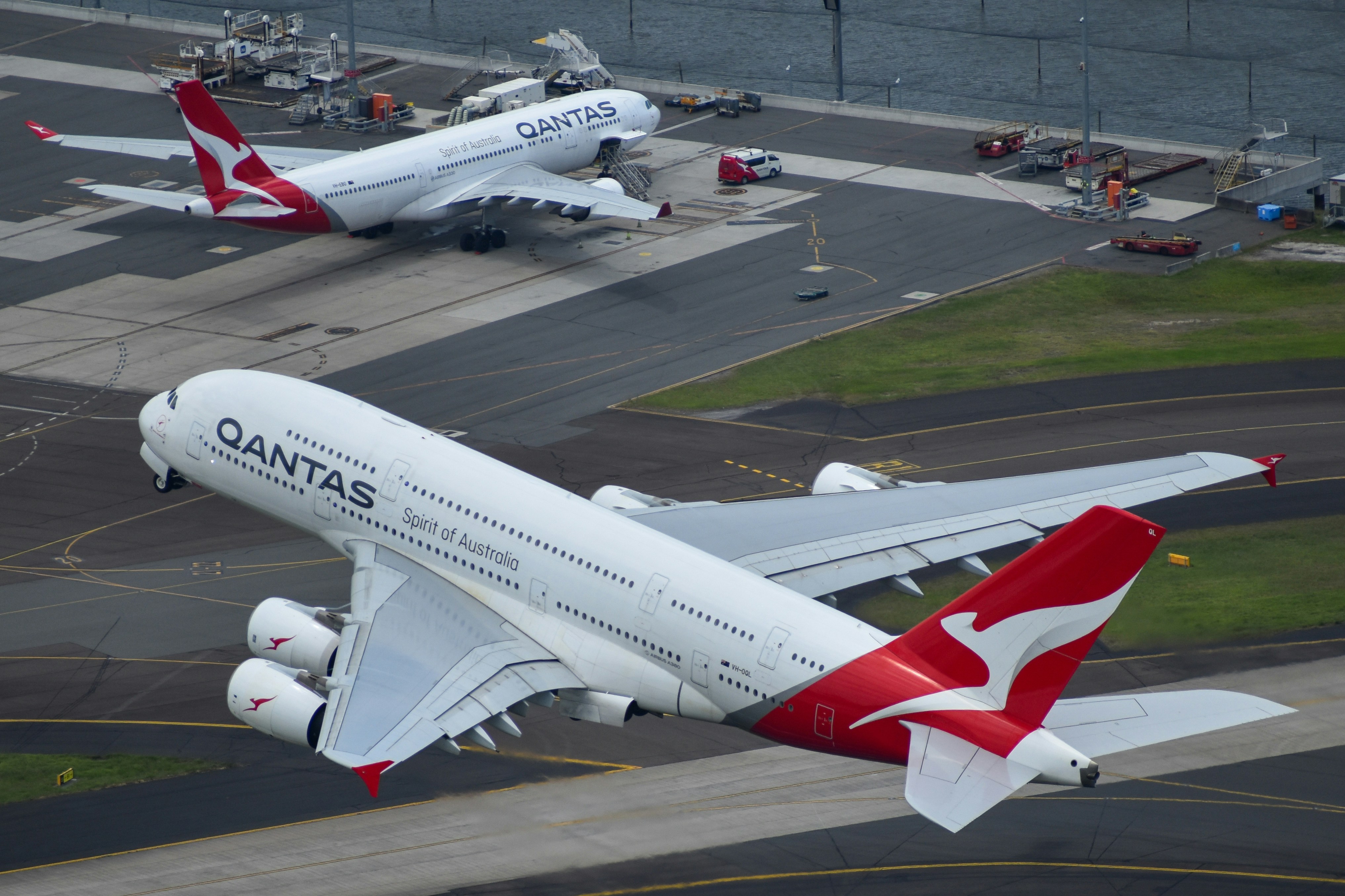 A large passenger jet flying over a runway, Qantas A380 at Sydney Airport