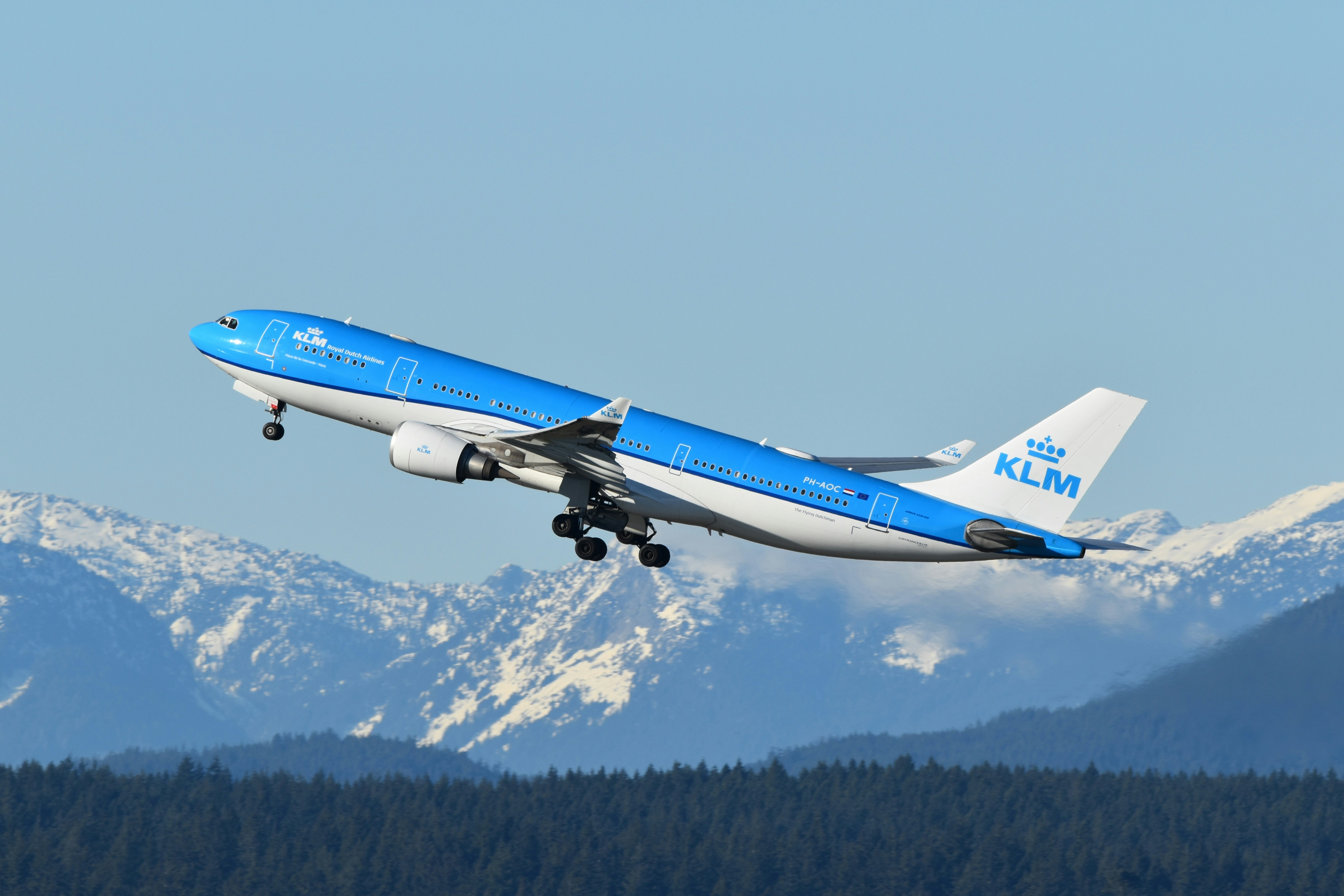 KLM's jet taking off with a view of mountains in the background