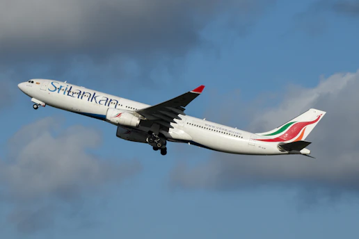 A large jetliner flying through a cloudy blue sky
