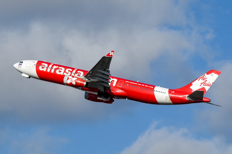 A large air plane flying through a cloudy sky