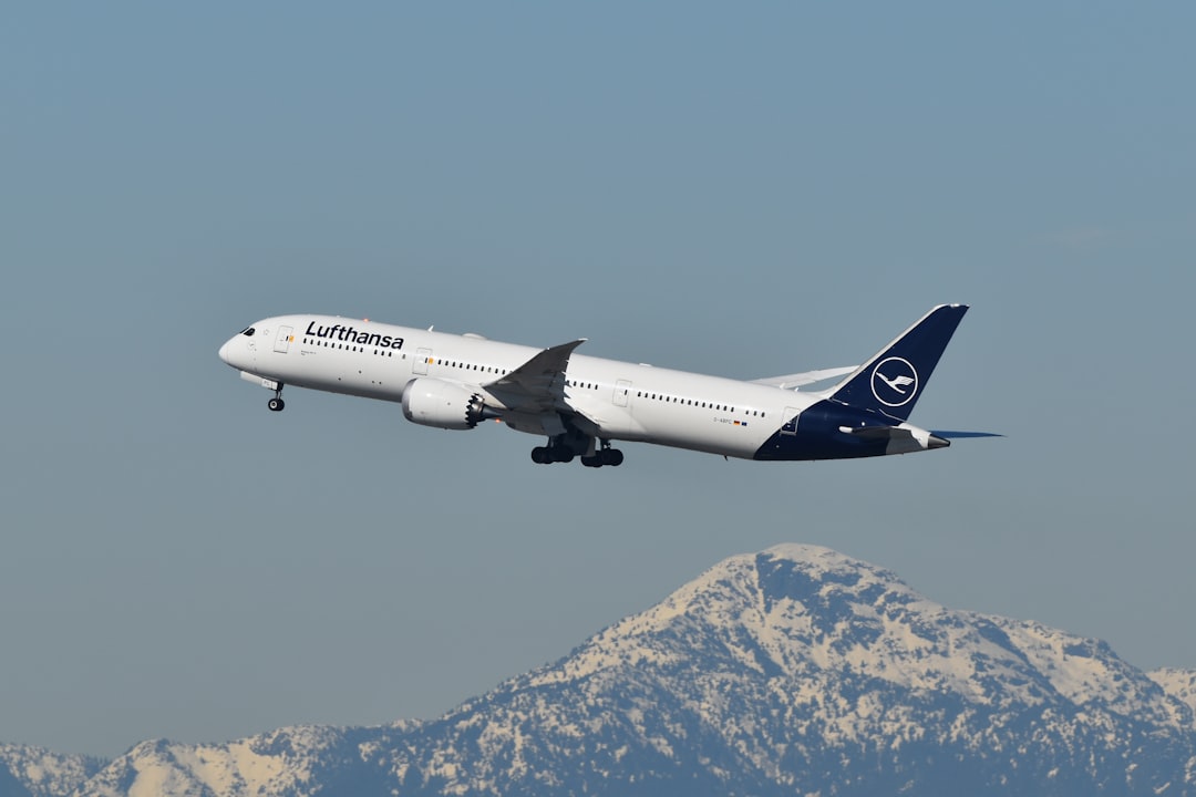 A large jetliner flying over a mountain range, Lufthansa 787 departing Vancouver