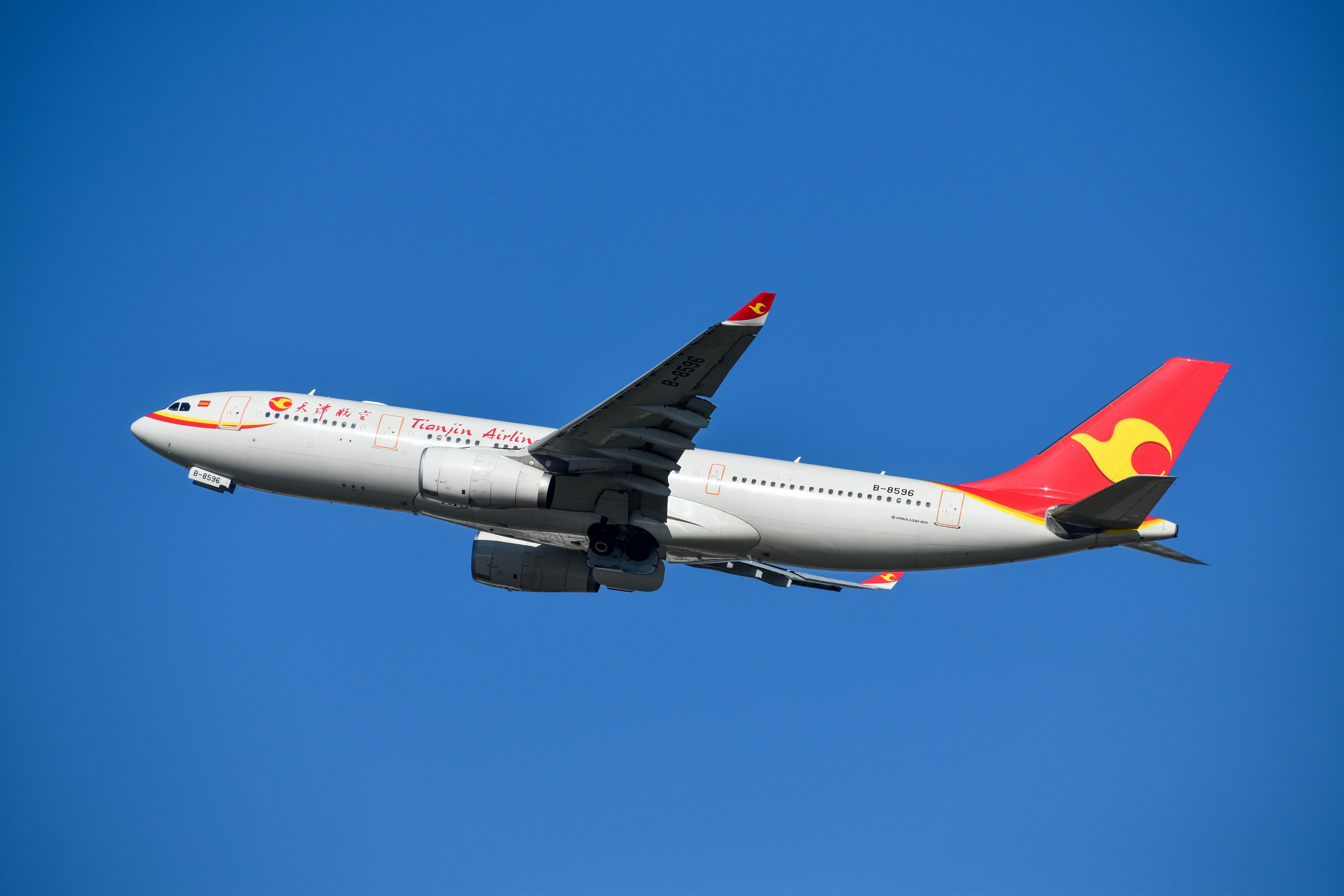 A large commercial airplane flying in the sky, Tianjin Airlines A330 departing Sydney
