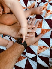 A man holding a baby while laying on a bed