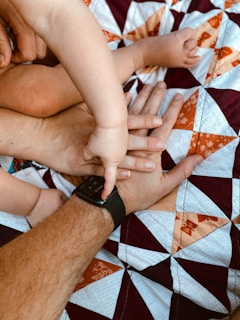 A man holding a baby while laying on a bed