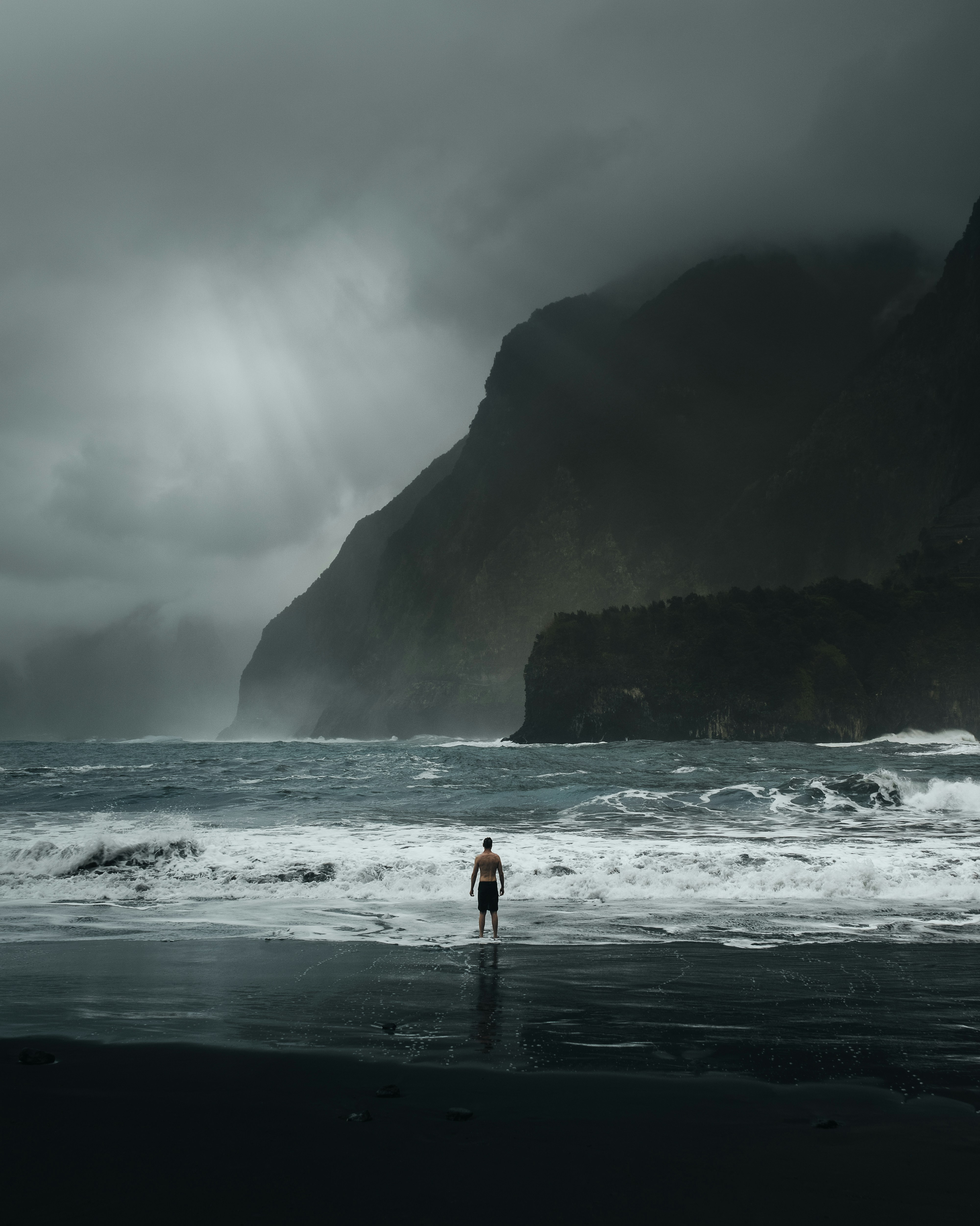 A person standing on a beach near the ocean