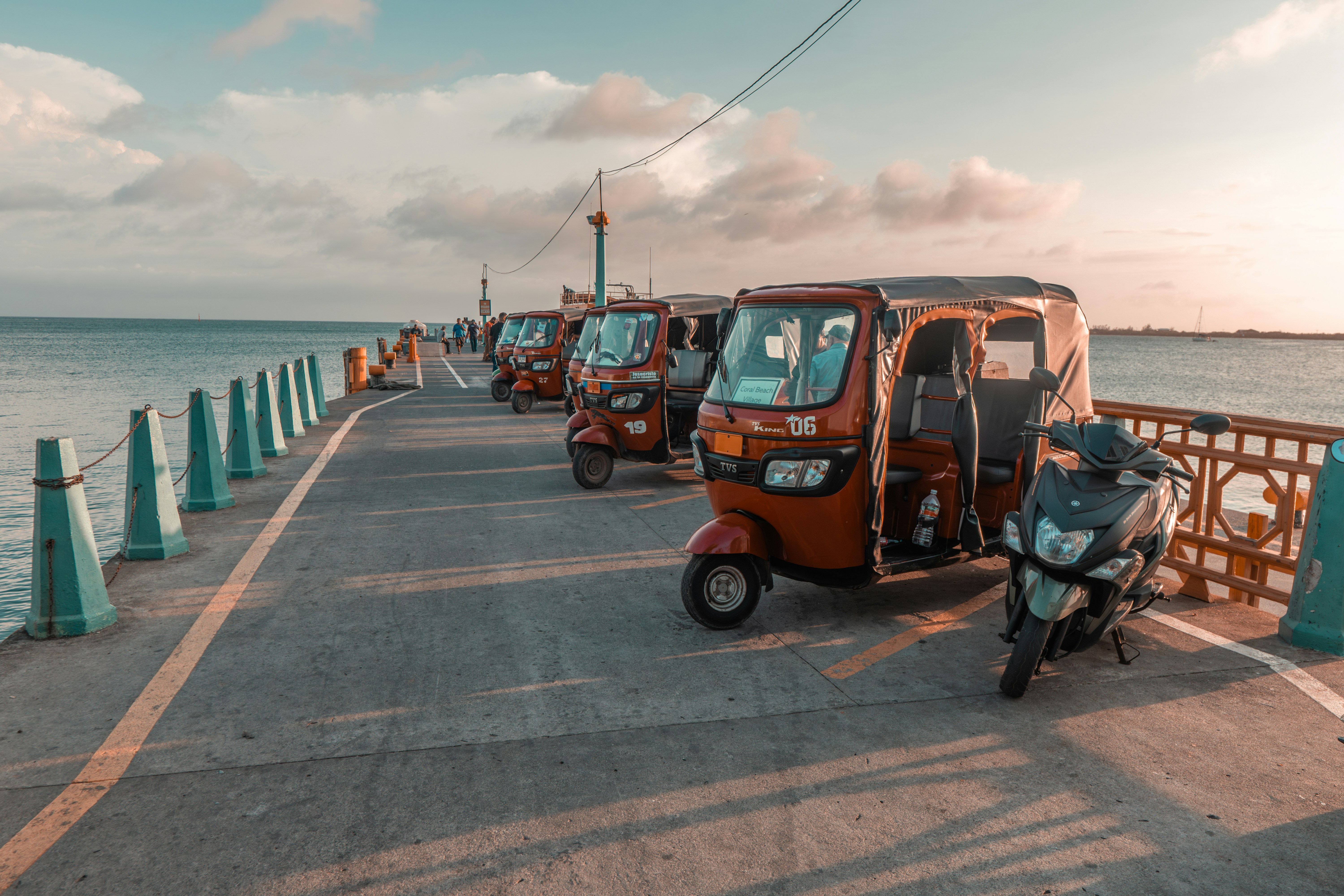 A row of three wheelers parked next to each other on a pier