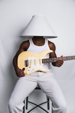 A man sitting on a chair holding a guitar