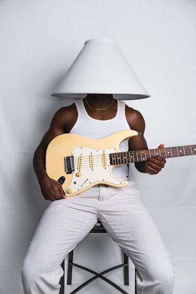 A man sitting on a chair holding a guitar