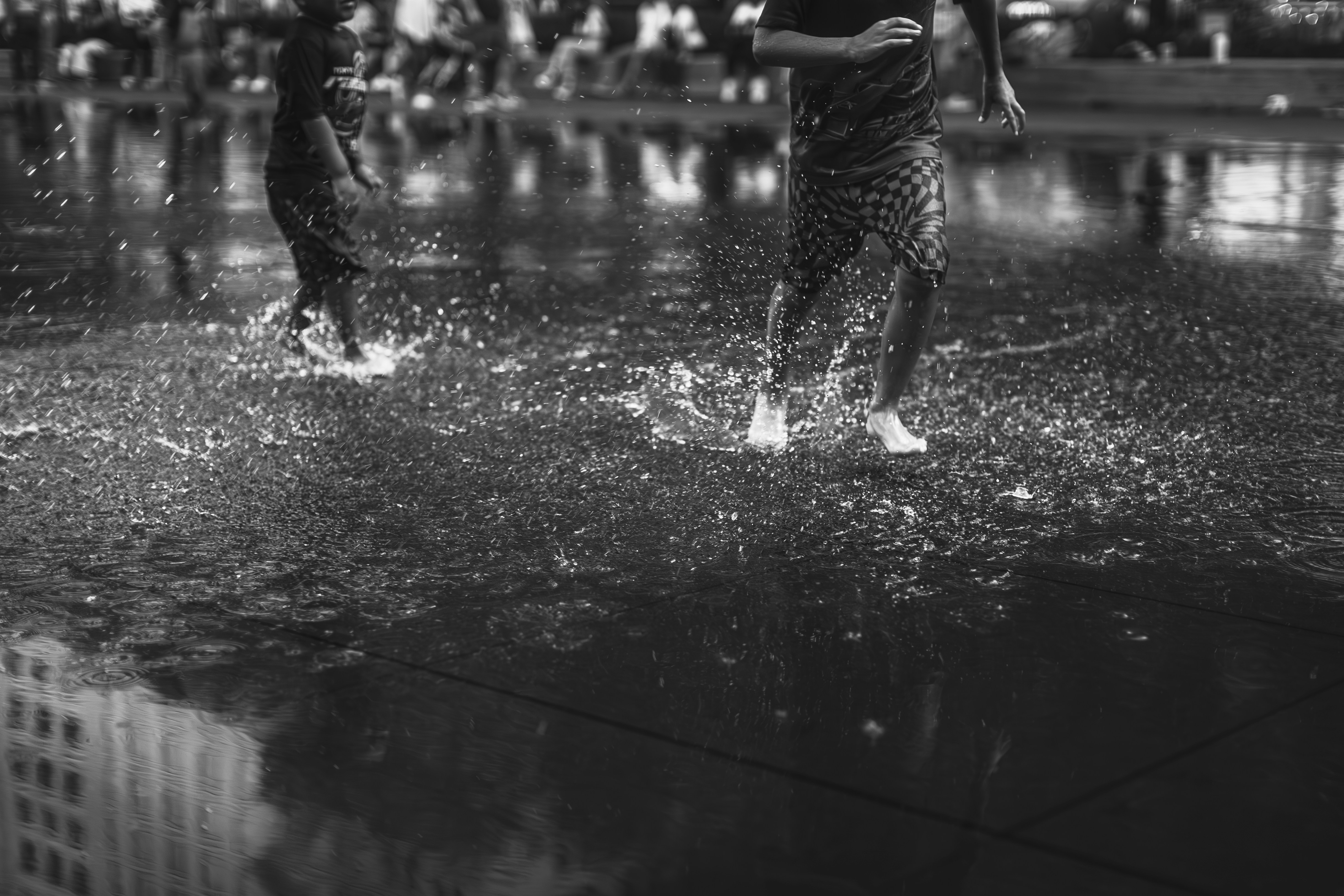 A solo football player practicing in the rain on a muddy pitch. The player is mid-kick, with water splashing around their feet. The image is gritty and determined, emphasizing the hard work and perseverance required to succeed in the sport.