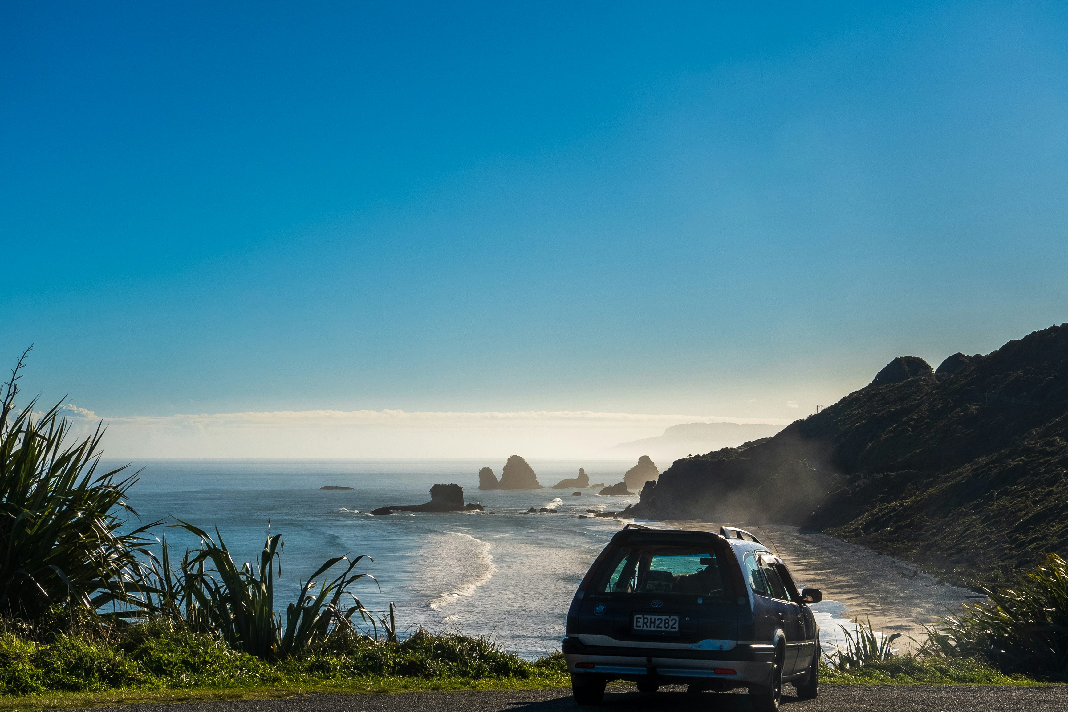 Ein Auto, das am Straßenrand in der Nähe des Ozeans geparkt ist