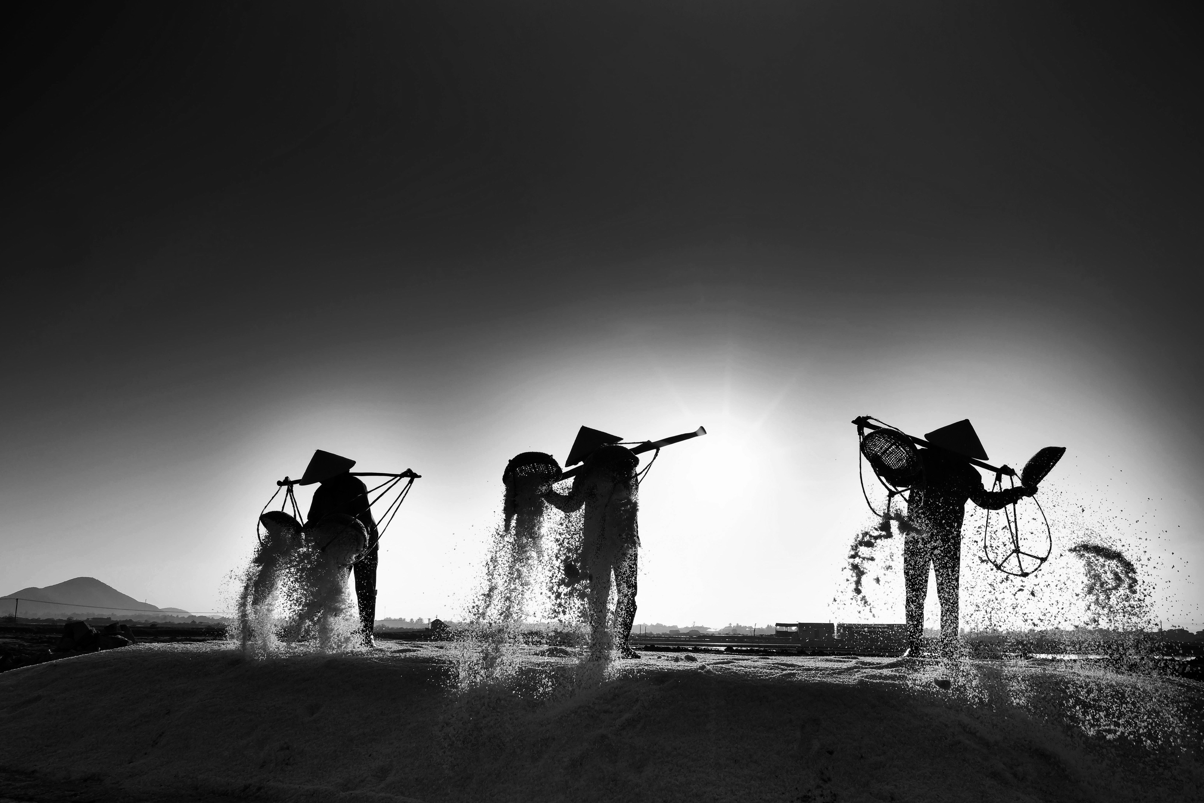 A group of people standing on top of a dirt hill