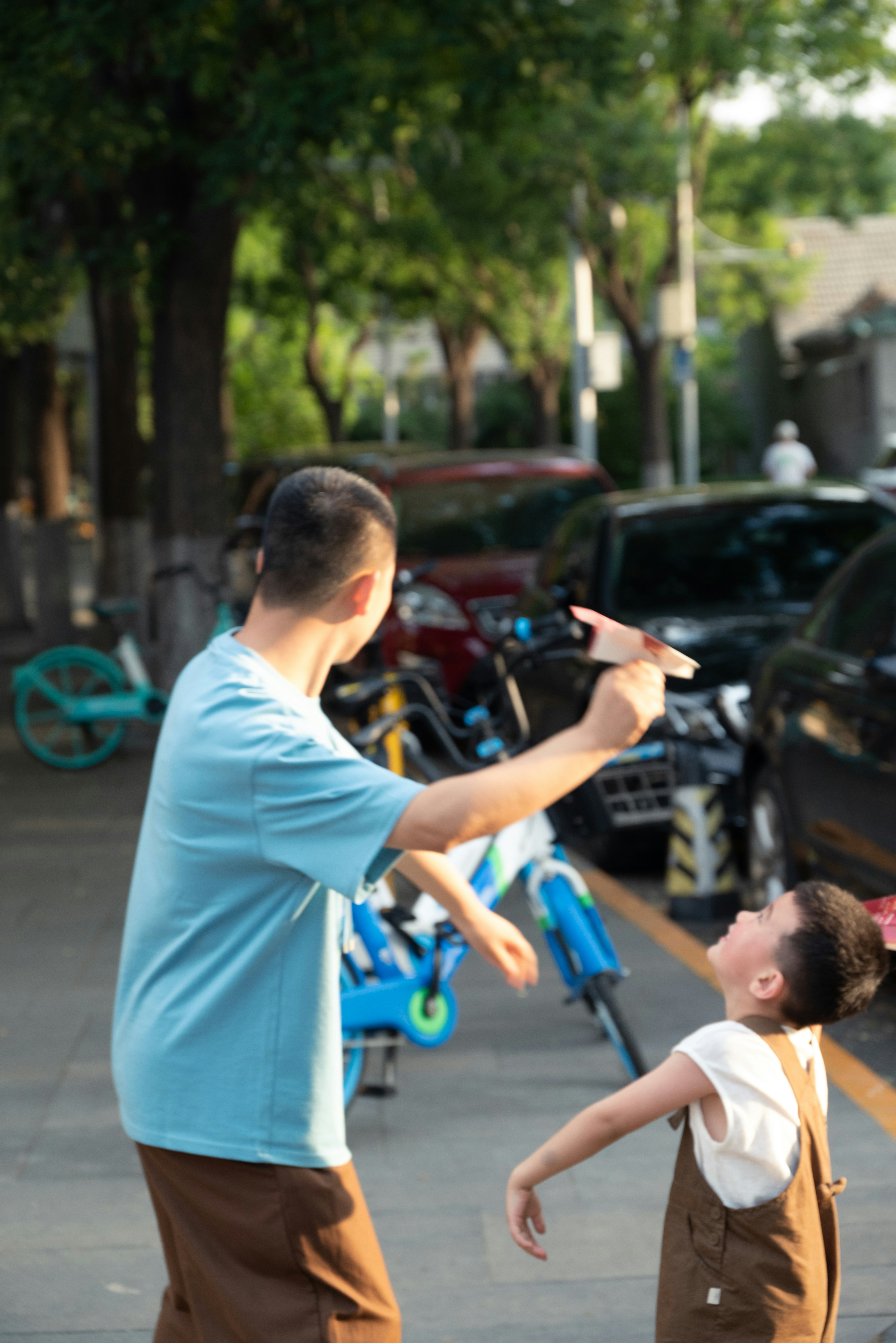 A man standing next to a little girl on a sidewalk