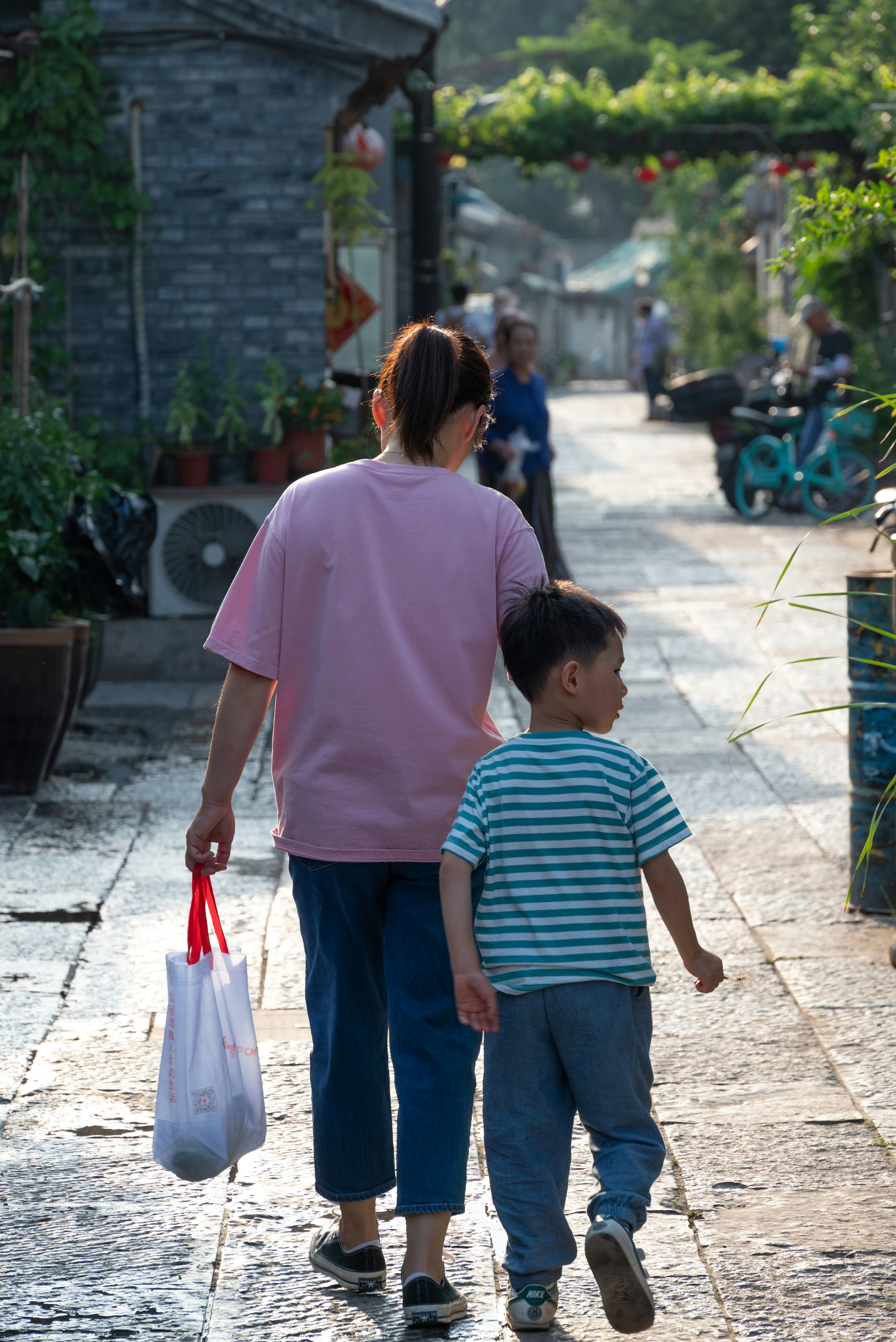 Una mujer y un niño caminando por una calle