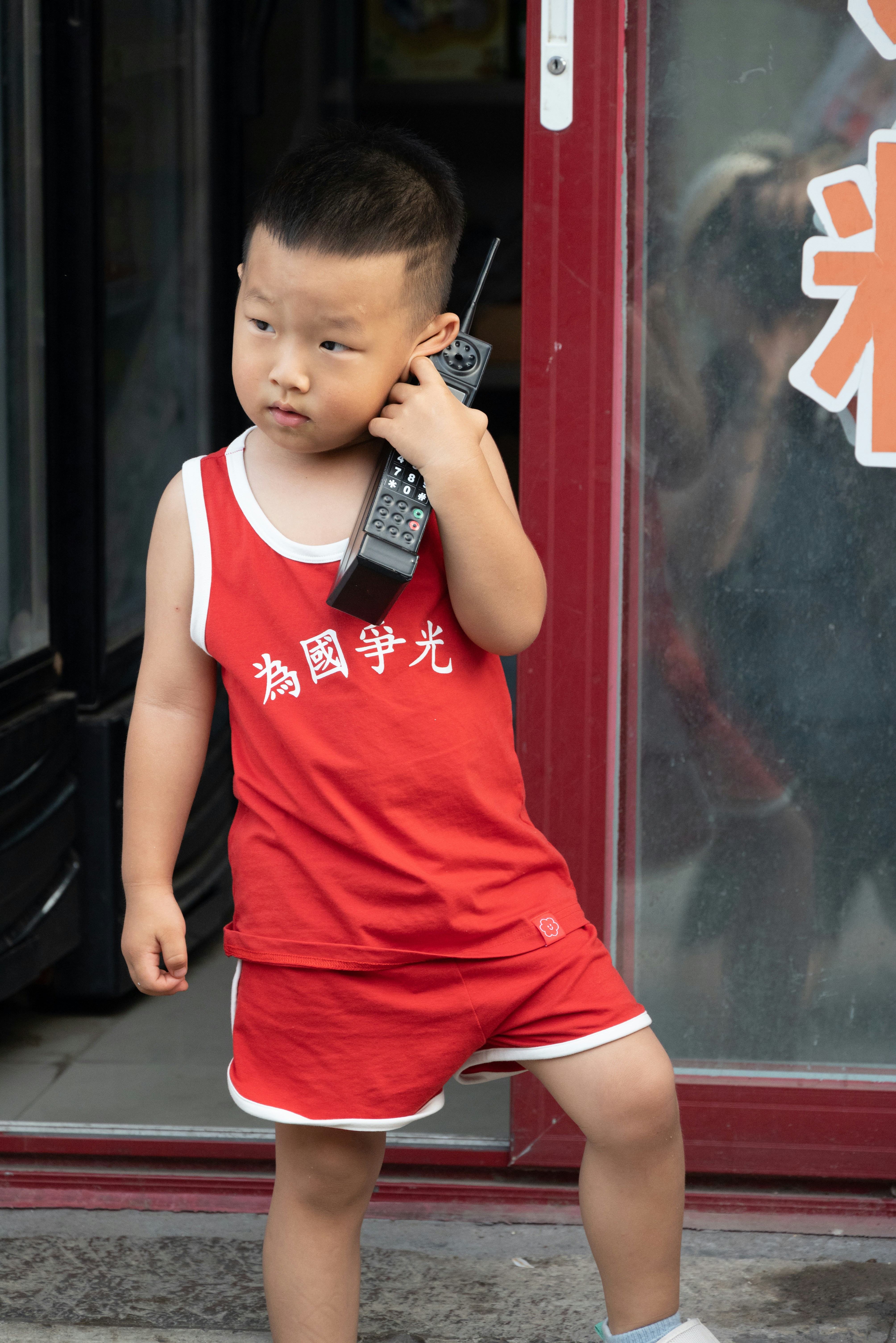 A young boy is talking on a cell phone