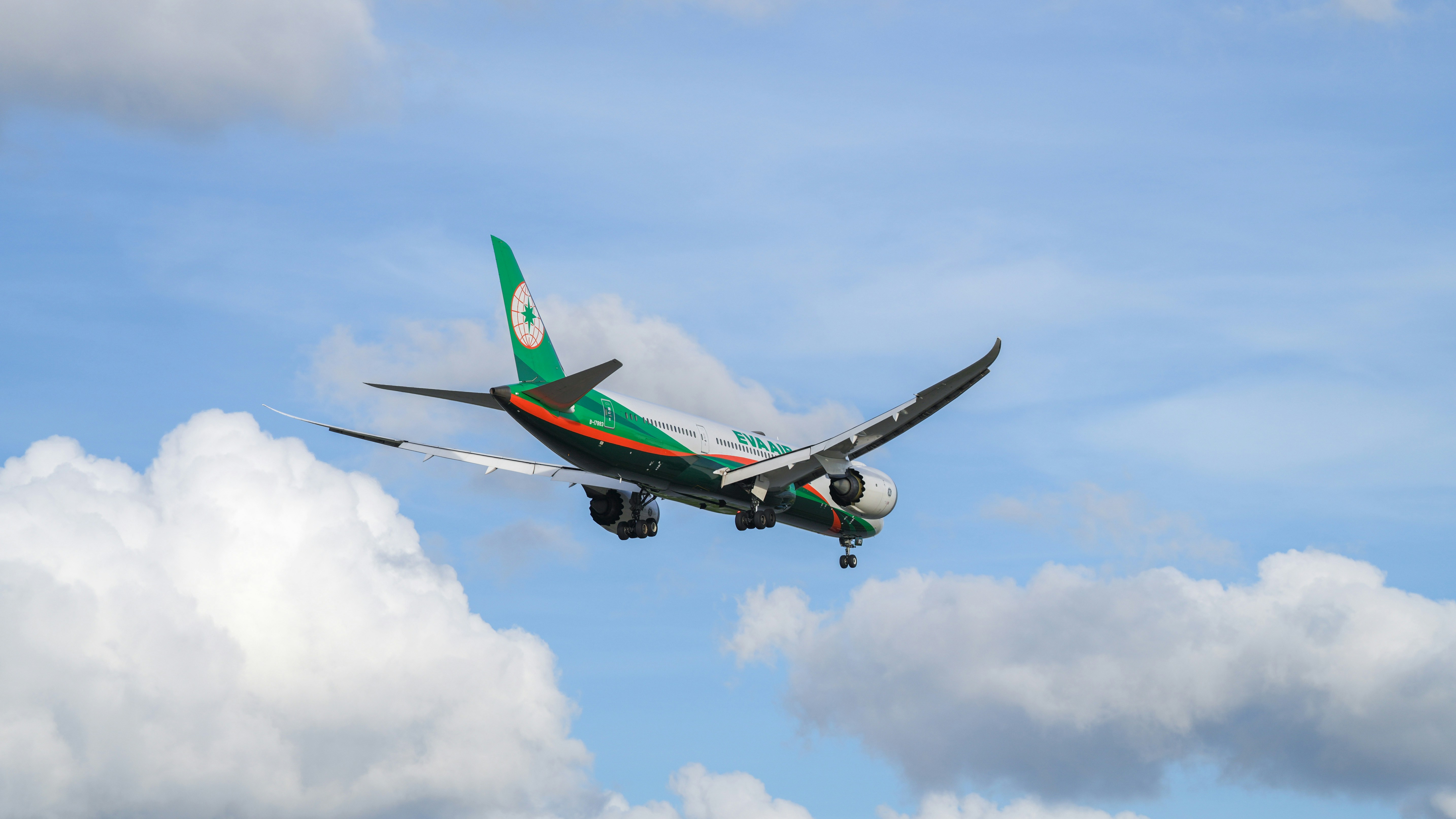 Un avión volando en el cielo con nubes de fondo