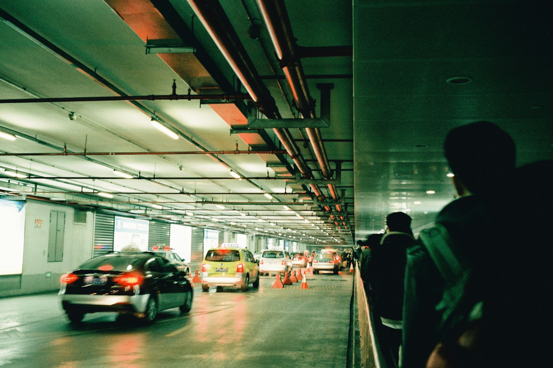 A group of cars driving through a parking garage