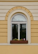 A window with a flower box on the side of it