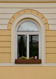 A window with a flower box on the side of it