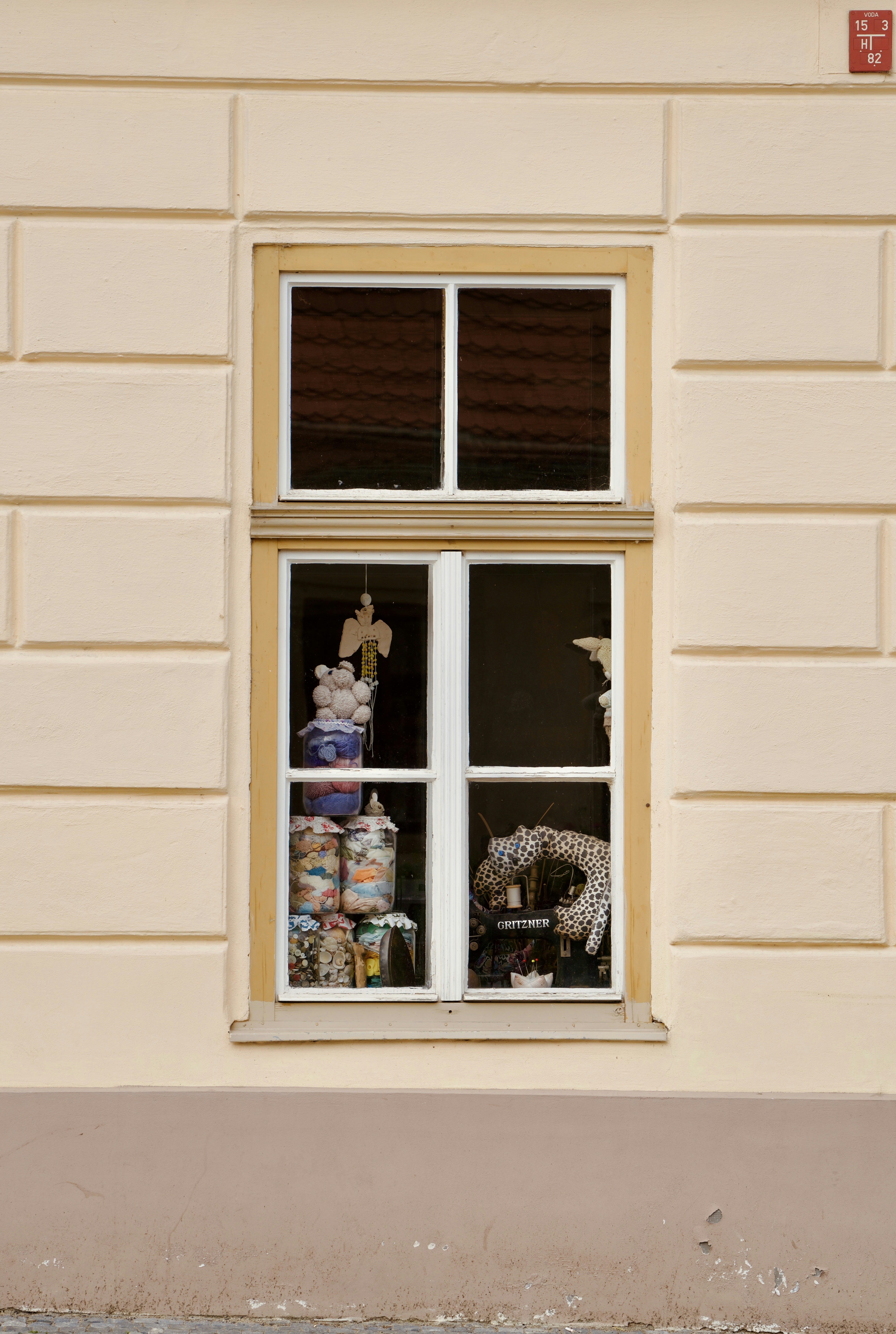 A cat sitting on a window sill in front of a building