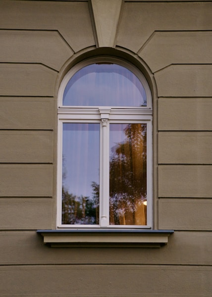 A window on a building with a tree in the background