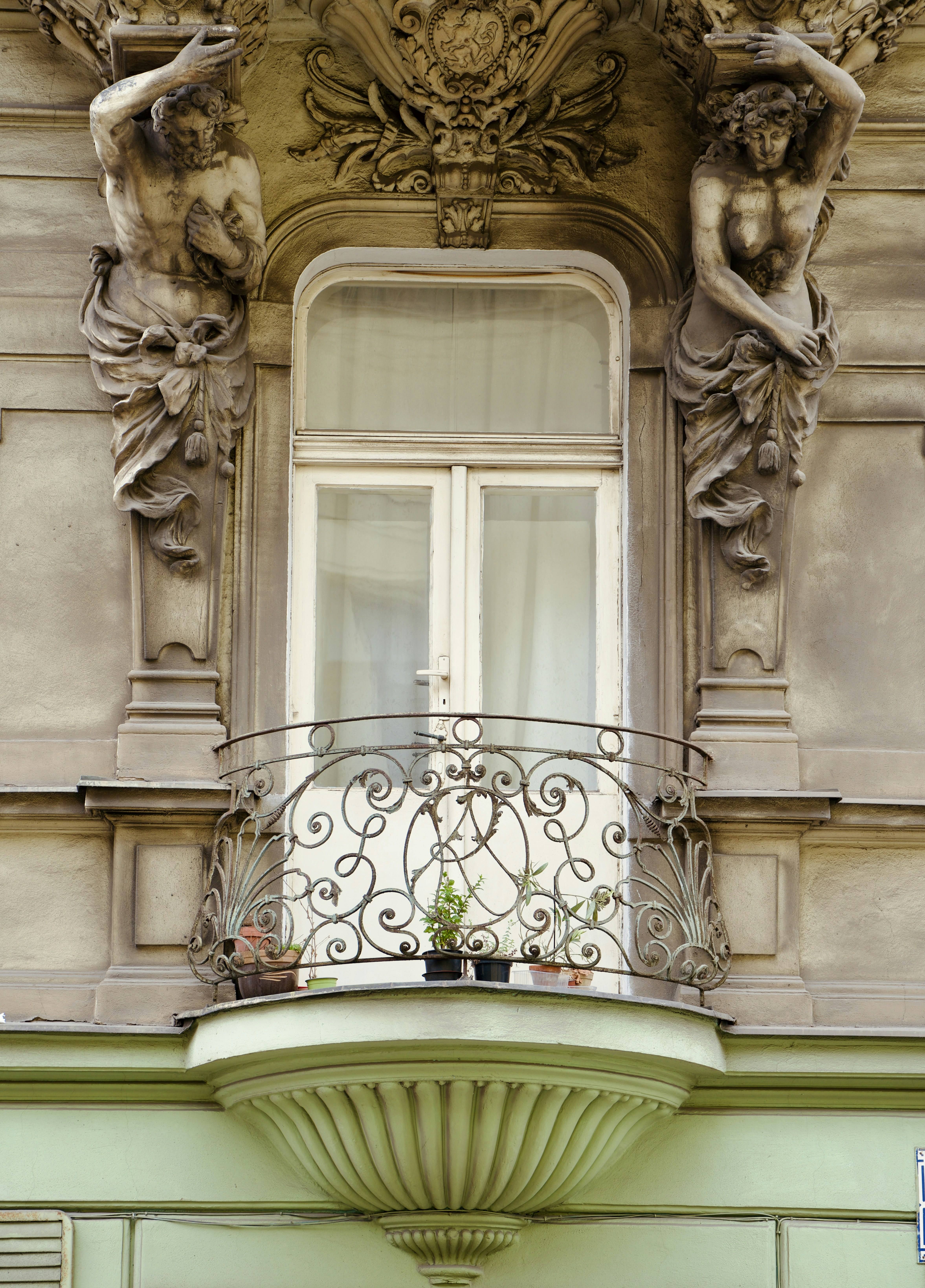 A balcony with statues on the side of a building
