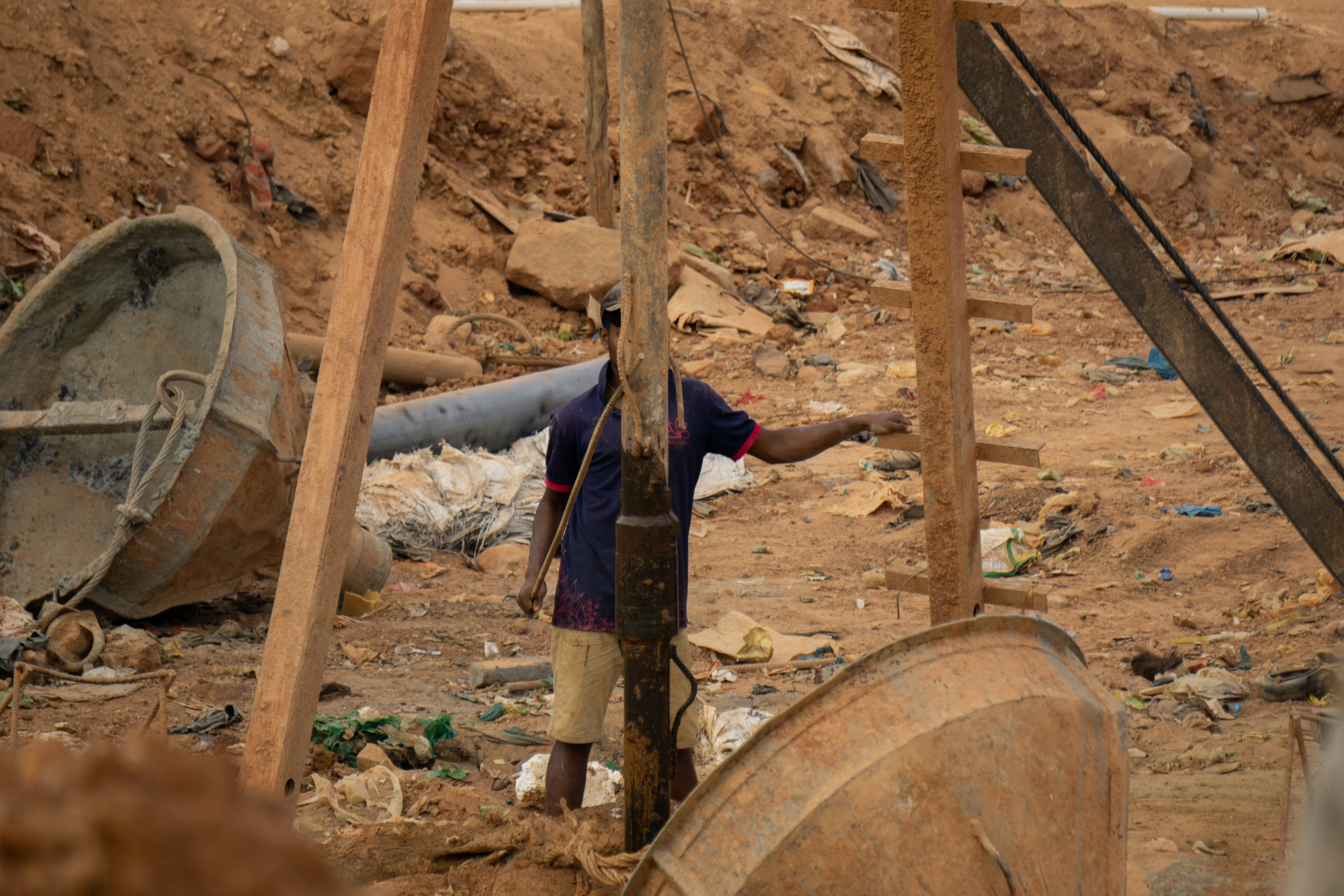 A man standing next to a wooden pole