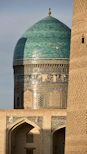 A tall building with a green dome on top of it
