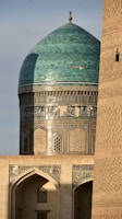 A tall building with a green dome on top of it