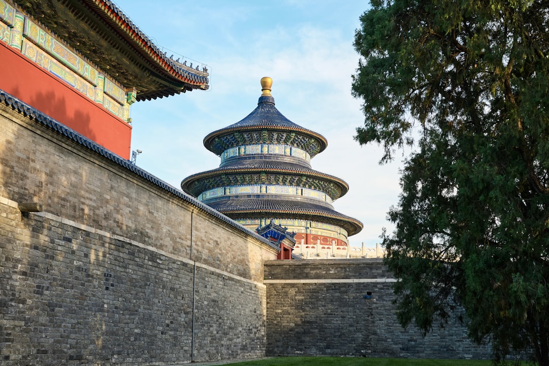 A stone wall with a building in the background,