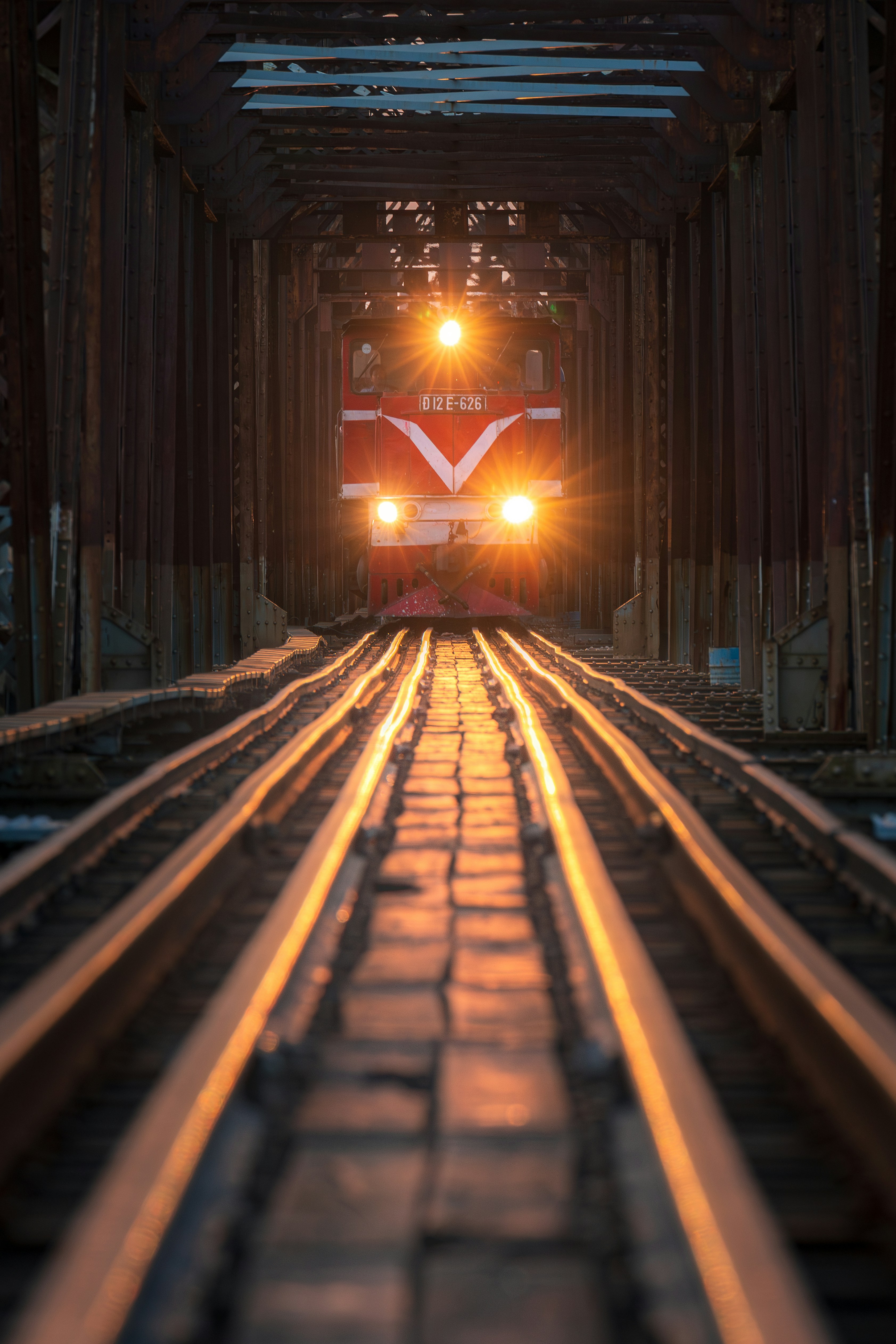 A train traveling down train tracks under a bridge
