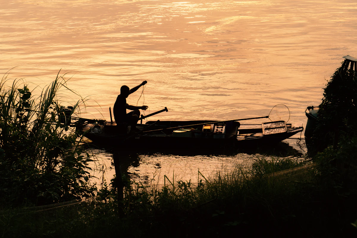 Angler standing in a drift boat on calm water