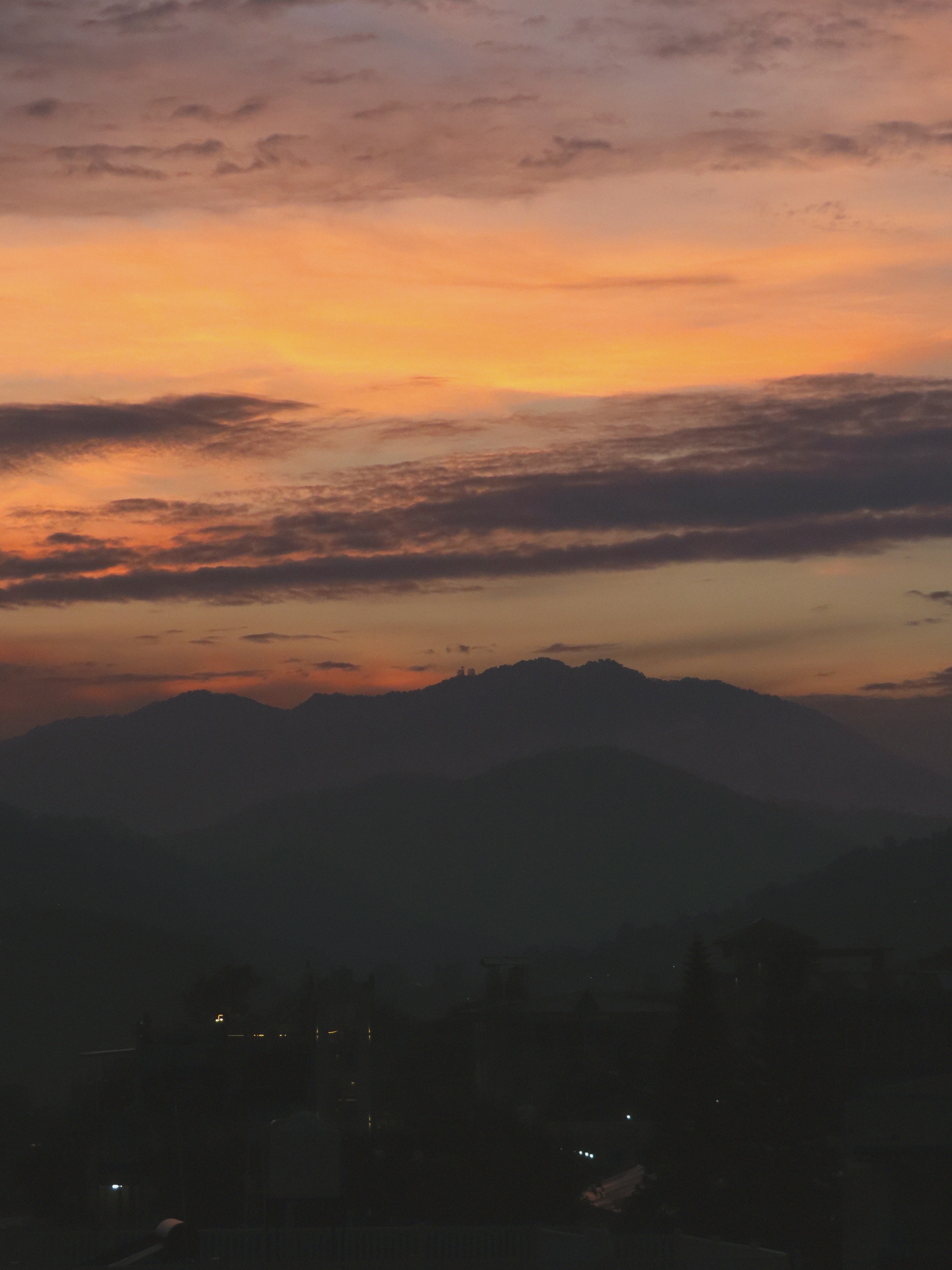 Dramatic mountain landscape at golden hour sunset with purple and orange clouds