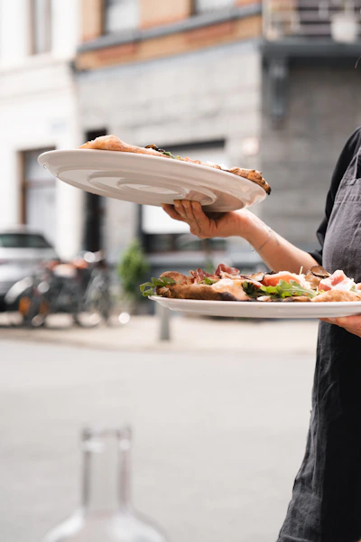 A man holding a plate of food on a city street