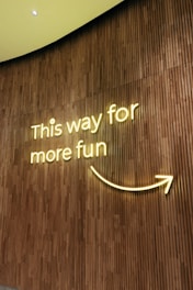 A sign on a wall that says this way for more fun